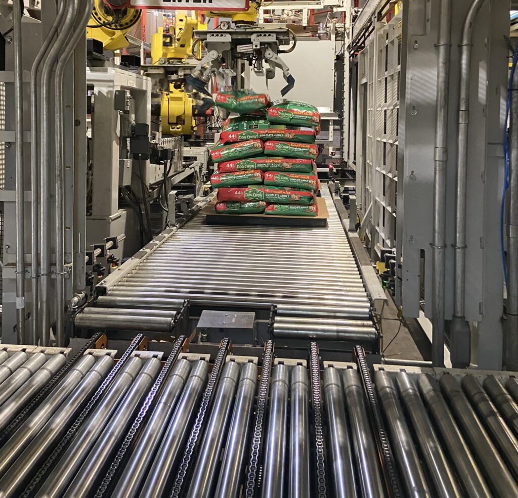 Dog Chow bags being stacked on a palette by an industrial robot.